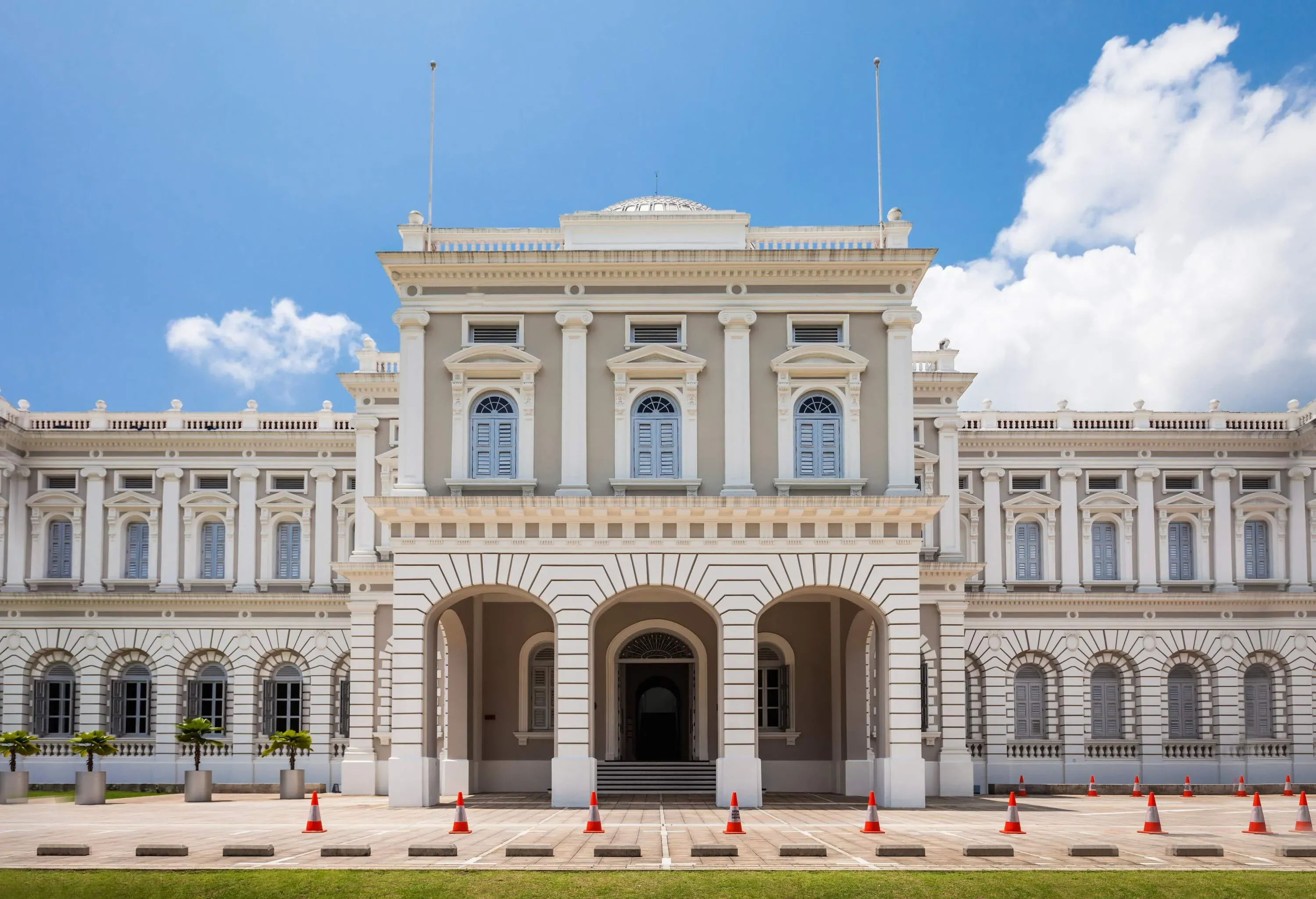 The facade of the National Museum of Singapore with traffic cones lined along the entrance.